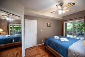 a bedroom with two beds and a ceiling fan at Goodview Le Mont-Luc in Gatineau