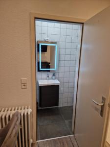 ein Bad mit einem Waschbecken und einem Spiegel in der Unterkunft Ferienwohnung Schwarzwald friedhofstraße 13 in Obersasbach