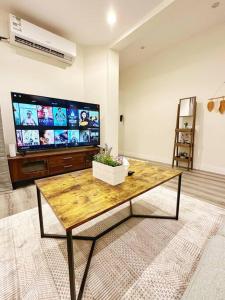 a living room with a coffee table and a flat screen tv at شقة جميلة، دخول ذاتي ٢٠١ in Riyadh