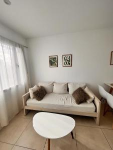 a living room with a white couch and a table at Alquiler temporario La Plata in La Plata