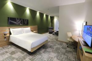 a bedroom with a bed and a tv and a desk at Hampton By Hilton Gdansk Old Town in Gdańsk