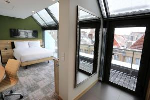 a bedroom with a bed and windows in a building at Hampton By Hilton Gdansk Old Town in Gdańsk +63 photos