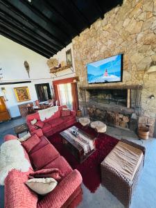 sala de estar con sofá rojo y chimenea de piedra en El Madejo - del Valle de Uco en Tunuyán