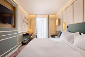 um quarto com uma grande cama branca e uma secretária em The Emerald House Lisbon - Curio Collection By Hilton em Lisboa