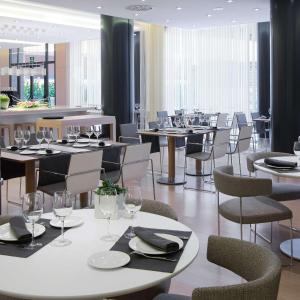um restaurante com mesas e cadeiras com copos de vinho em DoubleTree by Hilton Girona em Girona