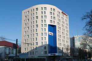 un edificio bianco con un grande cartello blu sopra di Hampton by Hilton Voronezh a Voronezh