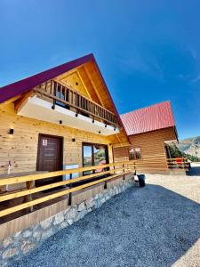 a large wooden cabin with a red roof at Hotel Te Liqeni in Peje