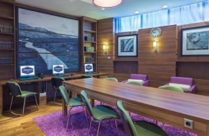 una sala de conferencias con una larga mesa de madera y sillas en Hampton by Hilton Voronezh, en Voronezh