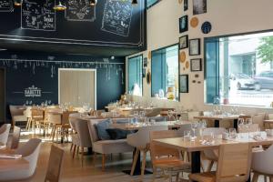 un restaurant avec des tables, des chaises et un mur de tableau noir dans l'établissement Hilton Garden Inn Paris Massy, à Massy