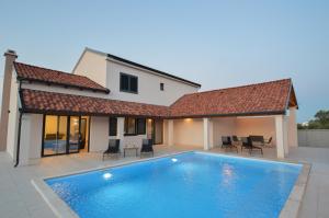 a swimming pool in front of a house at Villa DOKA in Zemuniki