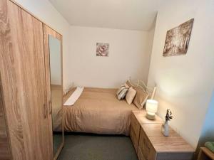 a bedroom with a bed and a mirror at 4 Bedroom Terrace house in Wellingborough