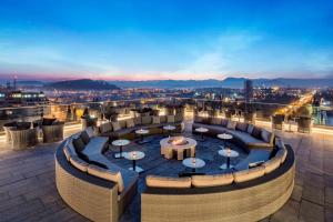 - une vue sur un restaurant sur le toit avec des tables et des chaises dans l'établissement Hilton Podgorica Crna Gora, à Podgorica