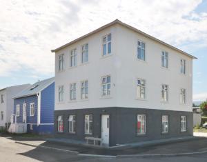a large white building with a blue house at G7 Akureyri Central Apartments in Akureyri