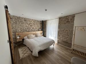 1 dormitorio con cama y pared de ladrillo en LA ALCOBA DE SAYAGO, en Bermillo de Sayago