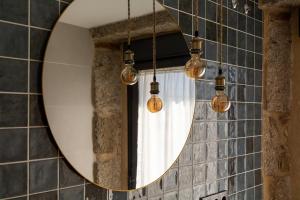 um espelho numa casa de banho com luzes e uma cortina em LA ALCOBA DE SAYAGO em Bermillo de Sayago