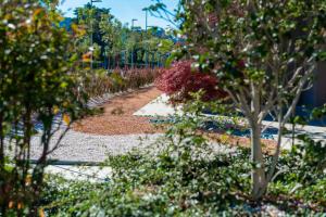 a garden with flowers and trees and a sidewalk at DoubleTree by Hilton Brescia in Brescia