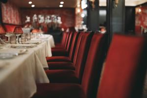 a row of tables in a restaurant with red chairs at Tower at The Boca Raton in Boca Raton