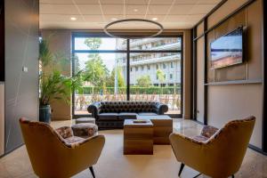 un soggiorno con divano e sedie di DoubleTree by Hilton Brescia a Brescia