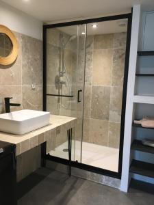 a bathroom with a sink and a shower at Le Préau : charmante maison au bord de l’Isère in Bourg-de-Péage