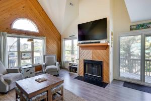a living room with a fireplace and a flat screen tv at Hot Tub, Pirate Fort and Fire Pit Outer Banks Home! in Nags Head