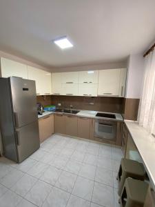 uma cozinha com um frigorífico de aço inoxidável e armários em Premier by Broci Apartments em Tirana