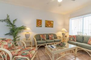 a living room with couches and a table at 2-level condo next to beach w view of the Gulf! in South Padre Island