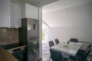 a kitchen with a table with chairs and a refrigerator at Luxury Apartments Milićević in Trebinje