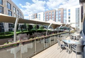 a patio with tables and chairs and umbrellas at DoubleTree by Hilton Moscow – Marina in Moscow