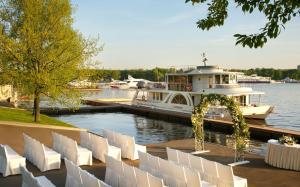 a boat docked at a marina with white chairs at DoubleTree by Hilton Moscow – Marina in Moscow