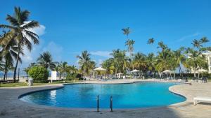 a pool at the resort with palm trees at Your Little Paradise - Juan Dolio in Juan Dolio