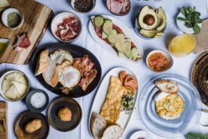 a table with plates of breakfast food on it at Casa Alberola Alicante, Curio Collection By Hilton in Alicante