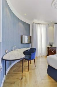 Habitación azul y blanca con mesa y silla en Casa Alberola Alicante, Curio Collection By Hilton, en Alicante