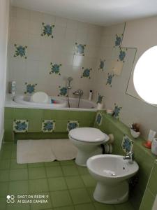 La salle de bains est pourvue de toilettes, d'un lavabo et d'une baignoire. dans l'établissement Casa Fiore, à Monte di Procida