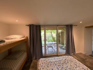 sypialnia z 2 łóżkami piętrowymi i patio w obiekcie Le Préau : charmante maison au bord de l’Isère w mieście Bourg-de-Péage