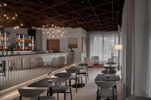 a restaurant with tables and chairs and a bar at Iceland Parliament Hotel, Curio Collection By Hilton in Reykjavík