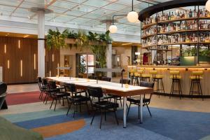 Motto By Hilton Rotterdam Blaak في روتردام: غرفة طعام مع طاولة وكراسي طويلة