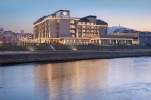 a large building next to a river at night at DoubleTree By Hilton Skopje in Skopje