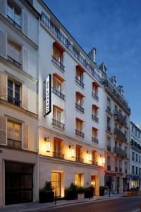 un bâtiment blanc avec un panneau sur son côté dans l'établissement Le Belgrand Hotel Paris Champs Elysees, Tapestry By Hilton, à Paris