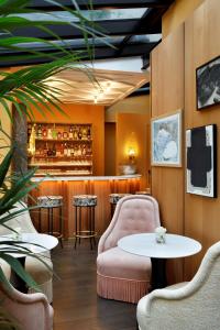 a restaurant with chairs and a table and a bar at Le Belgrand Hotel Paris Champs Elysees, Tapestry By Hilton in Paris