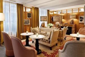 a living room with tables and chairs and a piano at Le Belgrand Hotel Paris Champs Elysees, Tapestry By Hilton in Paris +49 photos