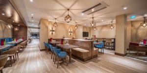 カフラマンマラシュにあるHampton By Hilton Kahramanmarasのテーブルと椅子のあるレストラン、バー
