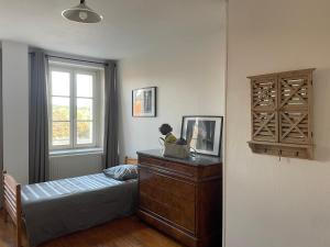 a bedroom with a bed and a dresser and a window at Grand appartement centre ville quartier calme in Neufchâteau