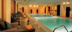 a large swimming pool in a hotel with chairs at Doubletree By Hilton La Torre Golf Resort in Roldán