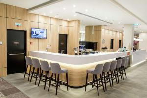 a lobby with a bar with stools around it at Hampton by Hilton Brest in Brest