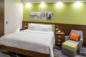 a bedroom with a large bed and a chair at Hampton by Hilton Brest in Brest +35 photos