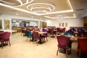 a restaurant with tables and chairs in a room at Hilton Garden Inn Ankara Gimat in Ankara