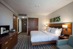 a hotel room with a bed and a television at Hilton Garden Inn Ankara Gimat in Ankara +8 photos