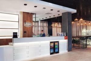 a restaurant with a white counter and a bar at Hampton By Hilton Lublin in Lublin