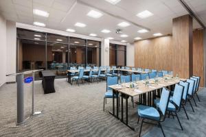 a conference room with a long table and blue chairs at Hampton By Hilton Lublin in Lublin
