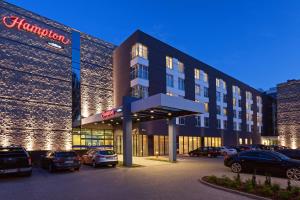 a large building with cars parked in a parking lot at Hampton by Hilton Warsaw Airport in Warsaw